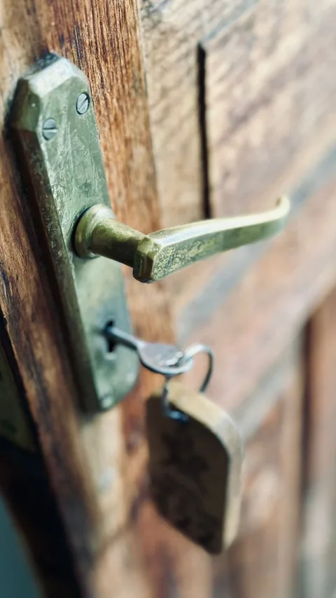 Antique key in heavy oak door of historic Parador castle hotel in Spain